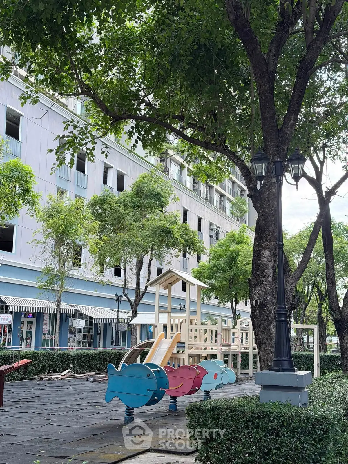 Charming residential building with lush greenery and a playful children's playground.