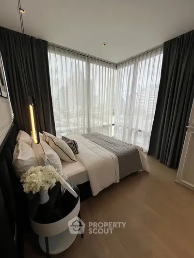 Luxurious corner bedroom with floor-to-ceiling windows and elegant decor in a modern apartment.