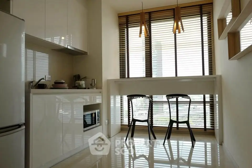 Modern kitchen with sleek design, featuring large windows and contemporary lighting.