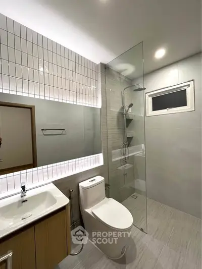 Modern bathroom with sleek design, glass shower, and elegant fixtures in a contemporary home.