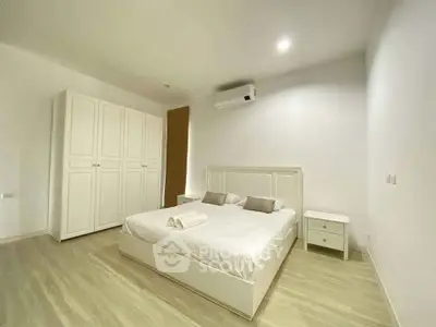 Spacious minimalist bedroom with modern furnishings and ample storage space.