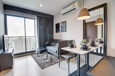 Modern living room with dining area, large window, and stylish decor in a high-rise apartment.