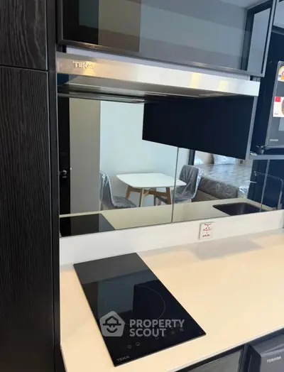 Modern kitchen with sleek black induction cooktop and stainless steel appliances