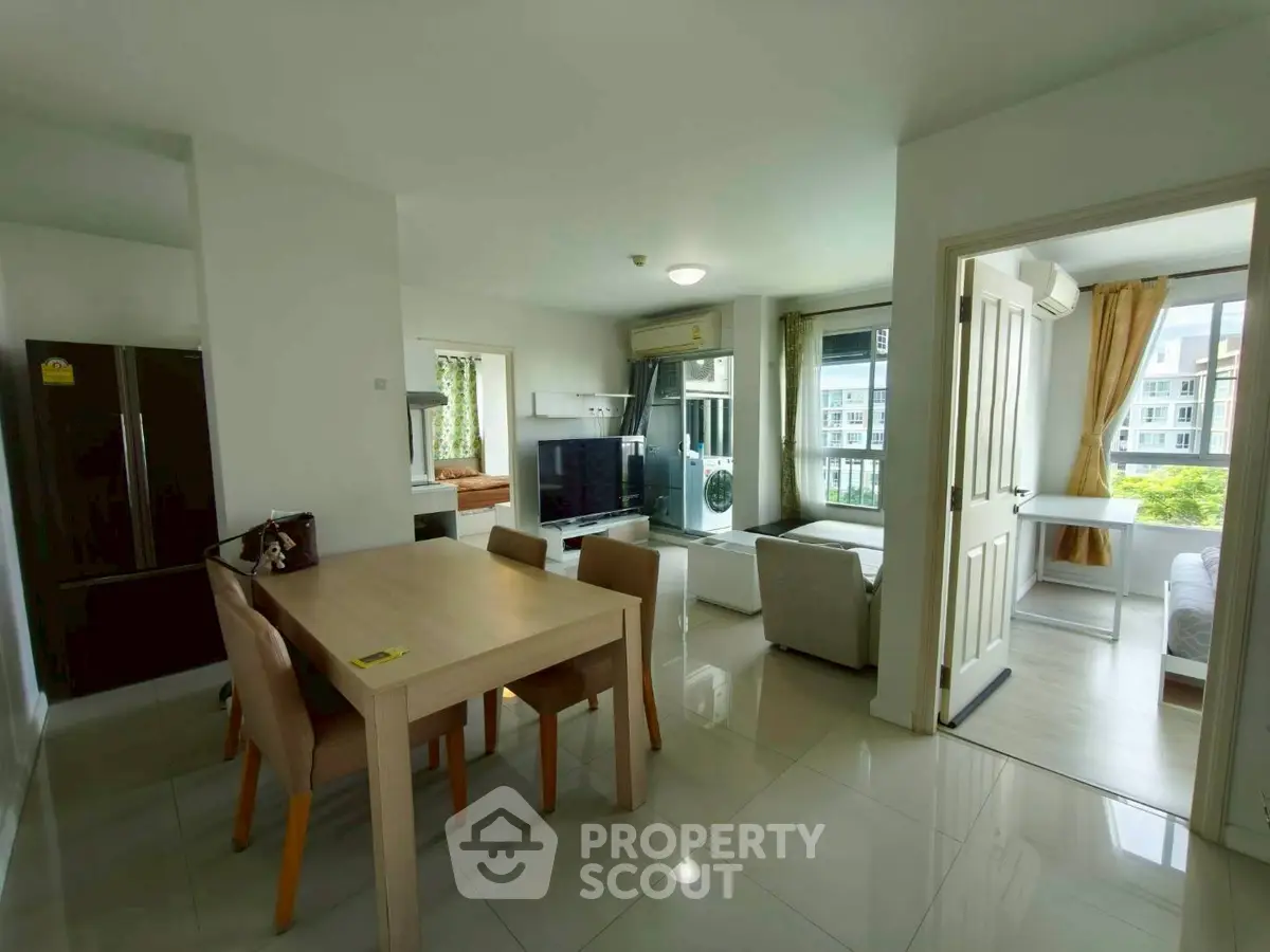 Spacious modern living room with dining area and large windows offering natural light and scenic views.