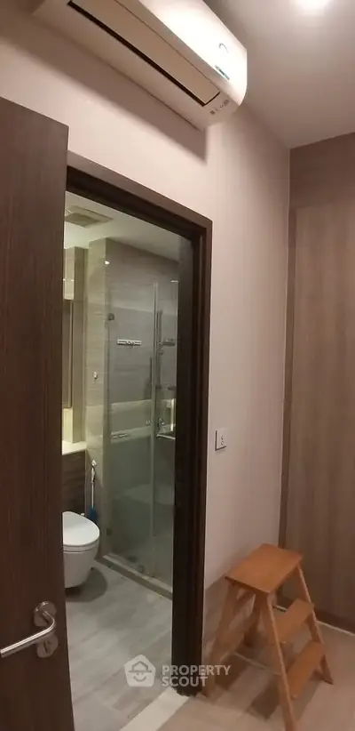 Modern bathroom with glass shower and air conditioning in a stylish apartment