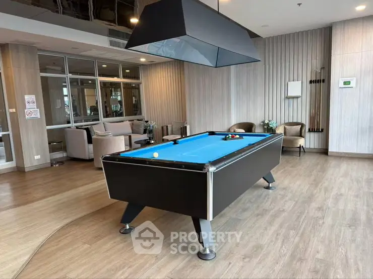 Modern recreational room with pool table and stylish seating area in luxury apartment complex.