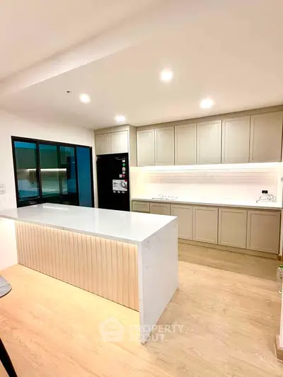 Modern kitchen with sleek cabinetry and spacious island in bright open layout.