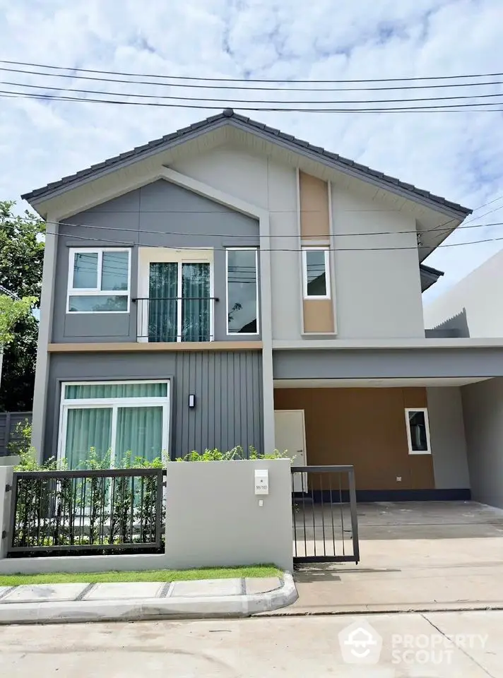 Modern two-story house with sleek design and spacious driveway in a serene neighborhood.