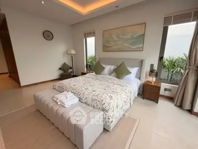 Luxurious bedroom with elegant decor and large windows offering natural light.