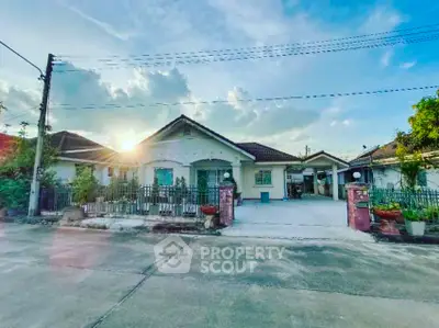 Charming suburban house with spacious driveway and lush greenery at sunset.