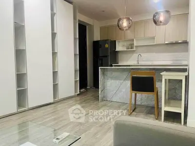 Modern kitchen with marble island and sleek cabinetry in open layout apartment.