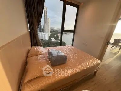 Modern bedroom with stunning city view and large window, featuring cozy bed and elegant decor.