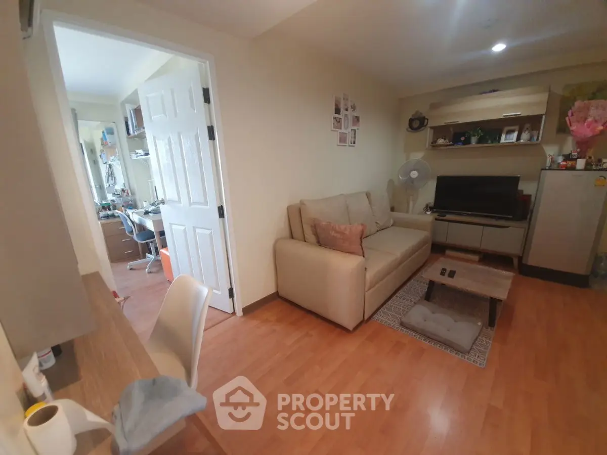 Cozy living room with modern decor and adjacent study area, perfect for urban living.
