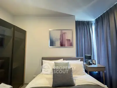 Cozy bedroom with modern decor and ample natural light from large windows.