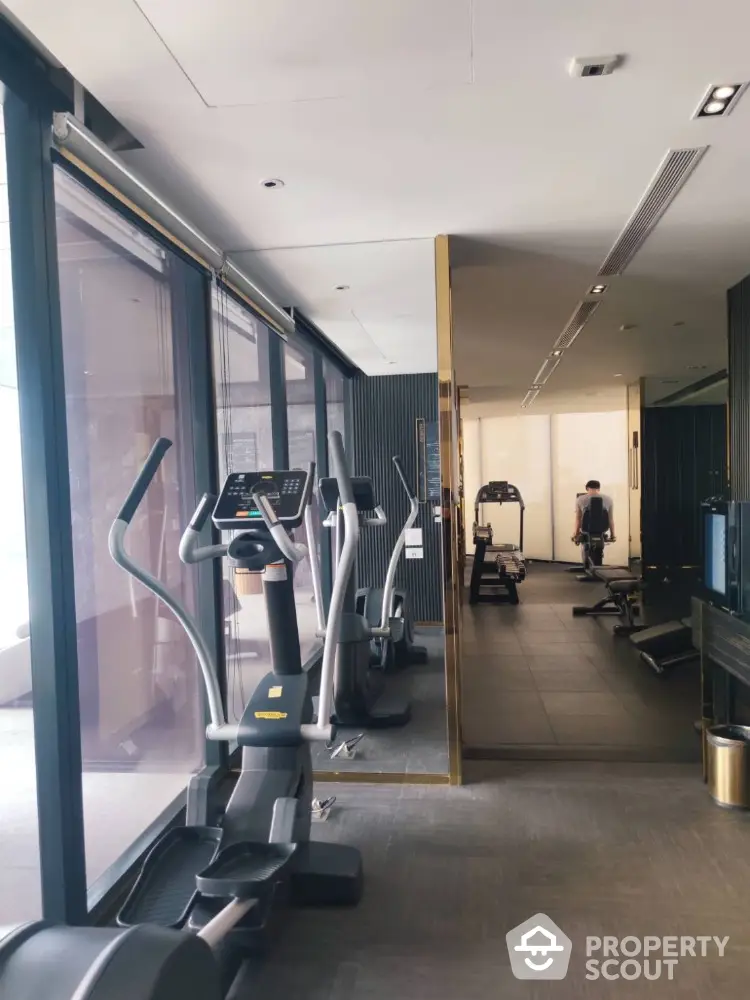 Modern gym with state-of-the-art equipment and large windows for natural light.