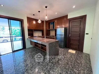 Modern kitchen with marble flooring and island, featuring sleek wooden cabinetry and stainless steel appliances.