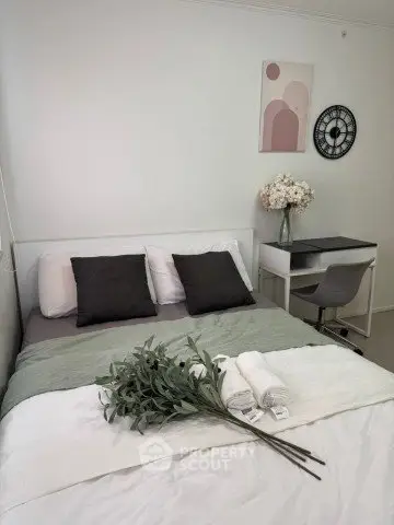 Cozy bedroom with modern decor, featuring a comfortable bed, stylish desk, and elegant wall art.