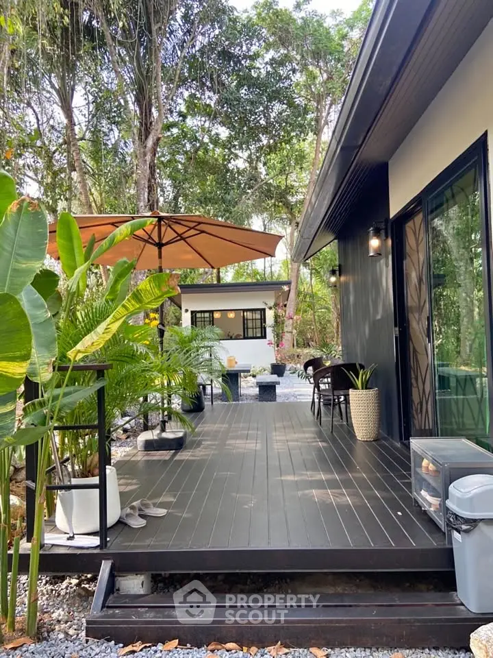Charming modern cabin with lush garden and spacious deck, perfect for outdoor relaxation.