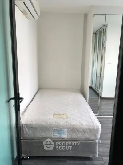 Compact bedroom with mirrored closet and air conditioning unit