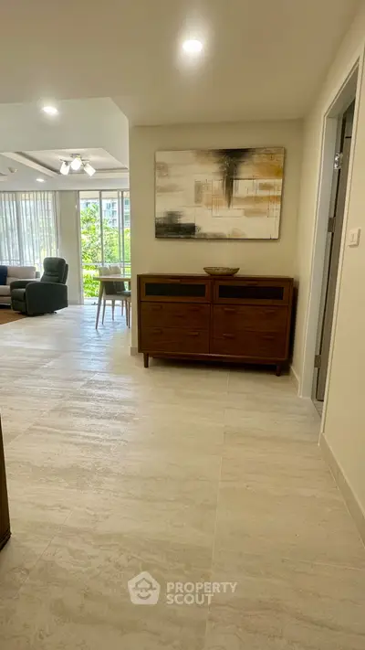 Spacious living area with modern decor and large windows offering natural light.