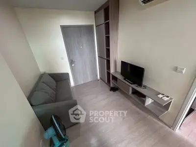 Cozy living room with modern sofa and TV, perfect for relaxation.