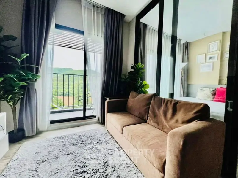Stylish living room with cozy sofa and balcony view in modern apartment