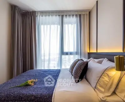 Luxurious bedroom with elegant decor and large window offering natural light.