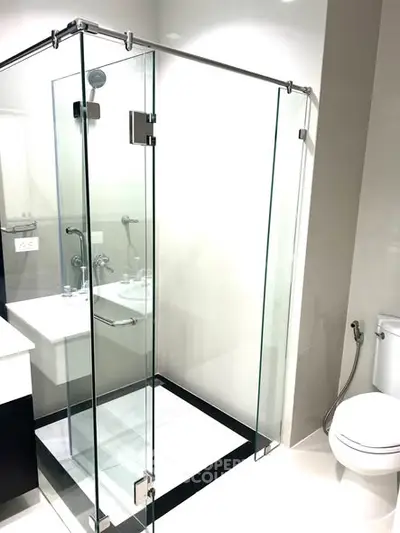 Modern bathroom with glass shower enclosure and sleek fixtures