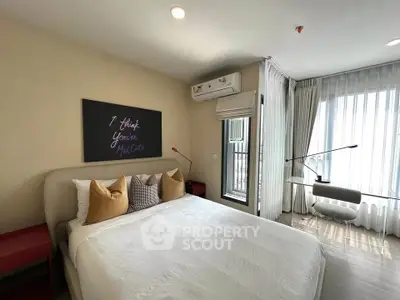 Modern bedroom with stylish decor and natural light, featuring a cozy bed and work desk.