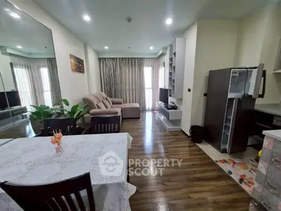 Spacious living room with modern decor and open layout, featuring a cozy sofa and dining area.