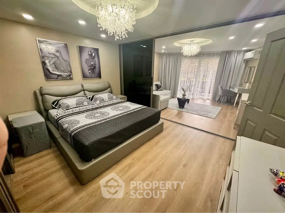 Luxurious bedroom with elegant decor and spacious layout, featuring a cozy seating area and modern lighting.