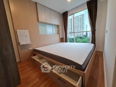 Modern bedroom with built-in storage and large window view of cityscape.