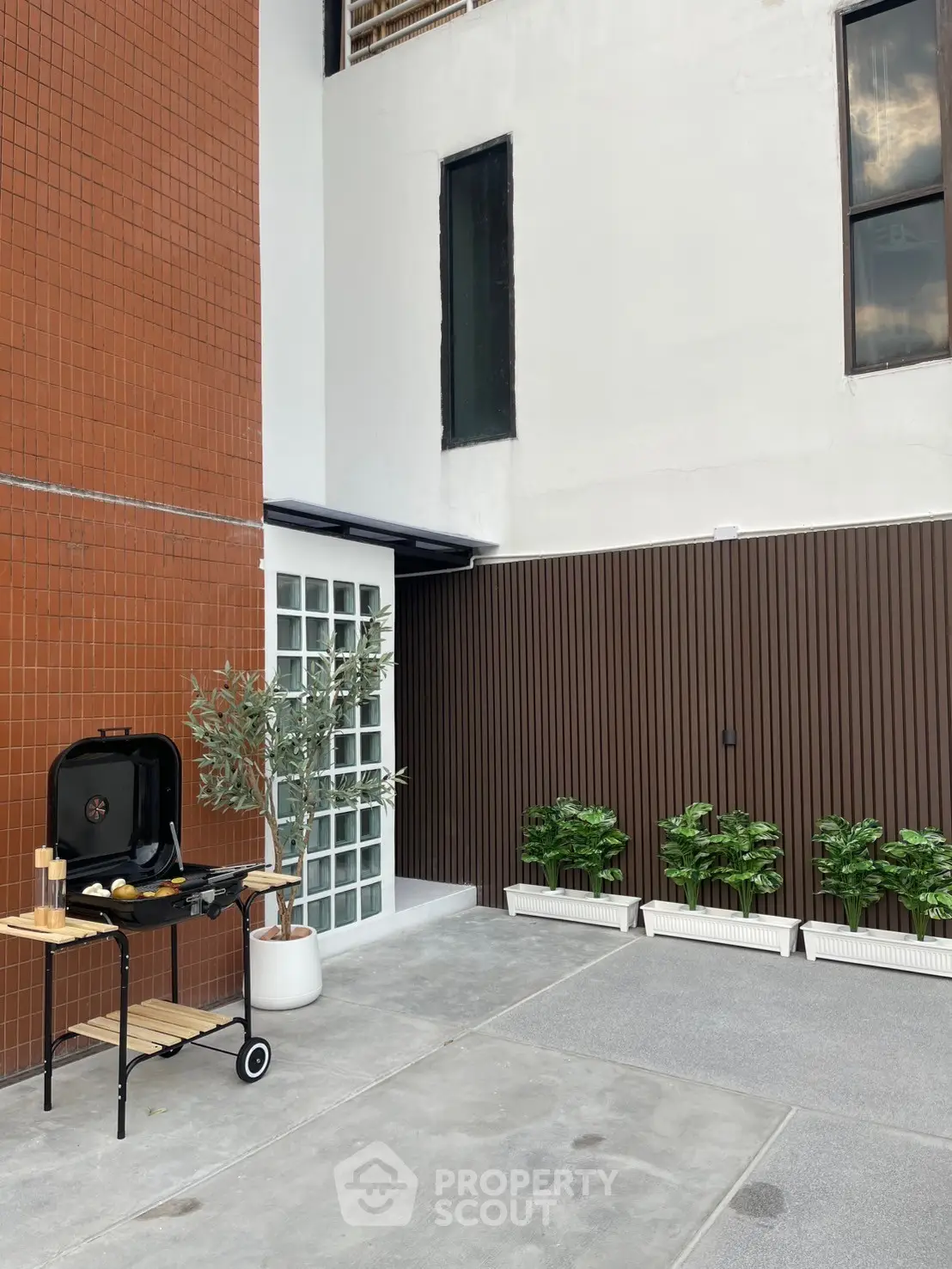 Modern outdoor BBQ area with sleek design and potted plants