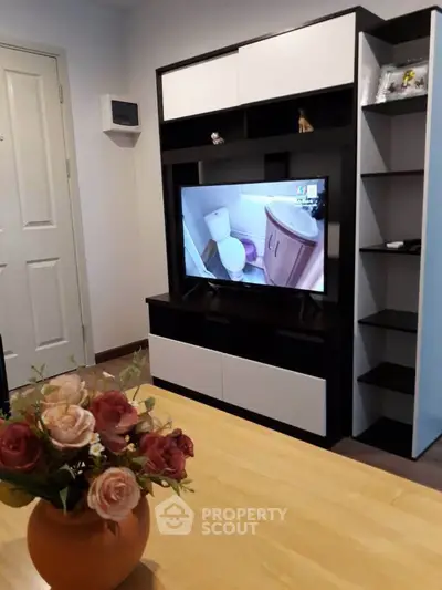 Modern living room with stylish shelving and TV, featuring elegant decor and a cozy atmosphere.