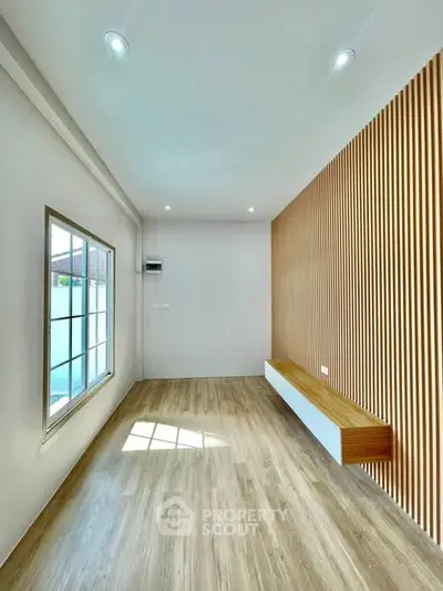 Modern minimalist room with wooden accent wall and large window, perfect for a cozy living space.