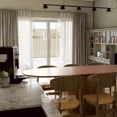 Spacious kitchen with open layout and modern dining area, featuring natural light and stylish decor.