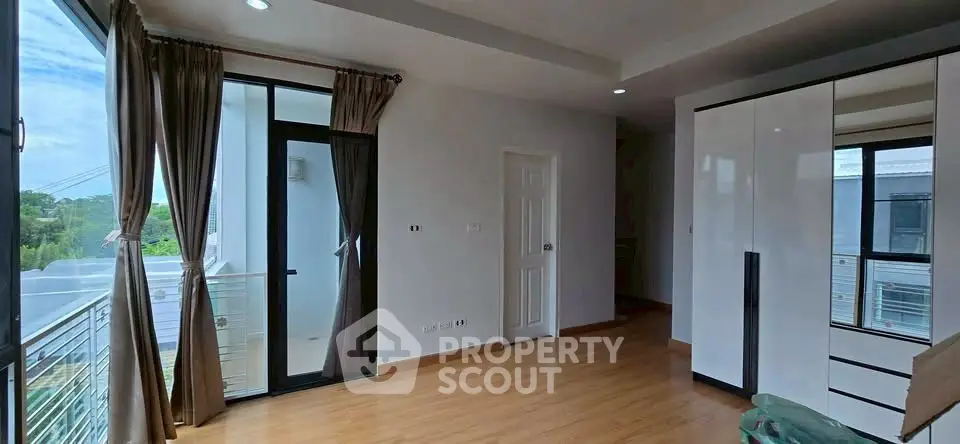 Spacious bedroom with large windows and balcony access in modern home