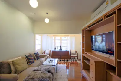 Cozy living room with modern decor and wall-mounted TV, perfect for relaxation.