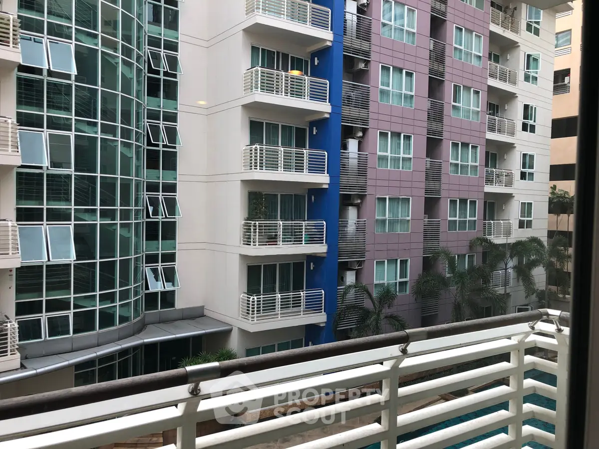 Modern apartment building with balconies and pool view, showcasing urban living.
