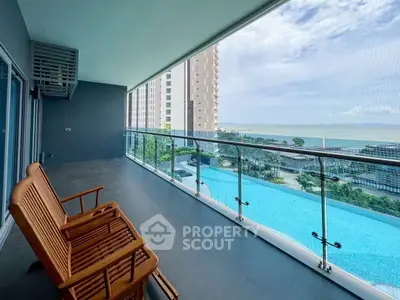 Spacious balcony with ocean view and pool in modern high-rise apartment
