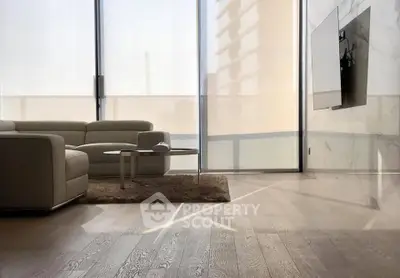 Modern living room with sleek furniture and large windows offering natural light.