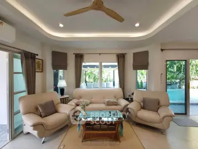 Spacious living room with elegant furniture and pool view, perfect for relaxation and entertaining.