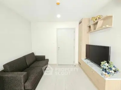 Modern living room with sleek furniture and built-in TV unit in a cozy apartment.