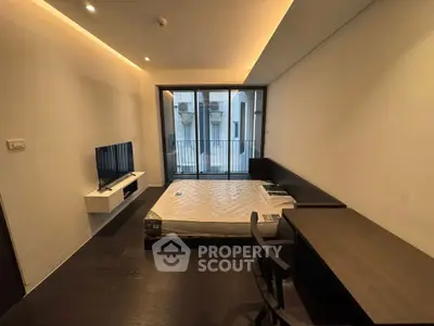 Modern bedroom with balcony access, featuring sleek furniture and ambient lighting for a cozy urban living experience.