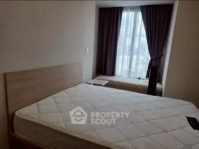 Cozy bedroom with large window and modern furnishings in a stylish apartment.