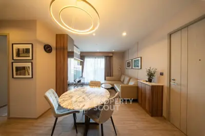 Modern living room with elegant dining area and stylish lighting in a cozy apartment.