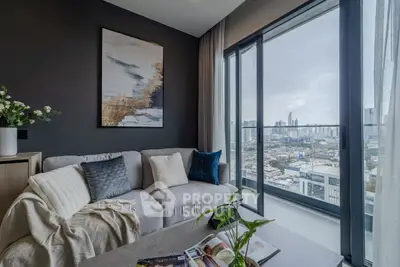 Modern living room with stunning city view from large balcony, featuring cozy sofa and elegant decor.