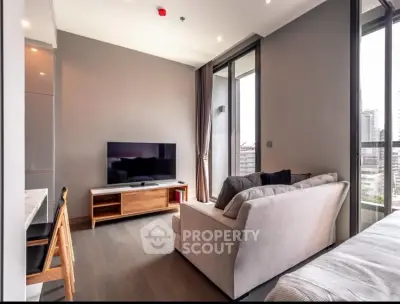 Modern living room with sleek design and city view, featuring a cozy sofa and large TV.