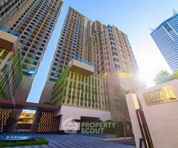 Stunning modern high-rise building with elegant architecture and lush greenery in urban setting.