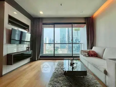 Modern living room with city view, sleek furniture, and large windows in a high-rise apartment.